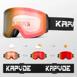 Photochromic snow goggle with a matte black frame, black face foam and a red photochromic lens in its light pale-pink state, on a black strap with white brand lettering. Below it, three small goggles show the lens darkening to a red mirror from cloud to sun, next to the flat strap.