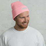 Man wearing the baby pink Skeezy cuffed beanie with white SKEEZY embroidery