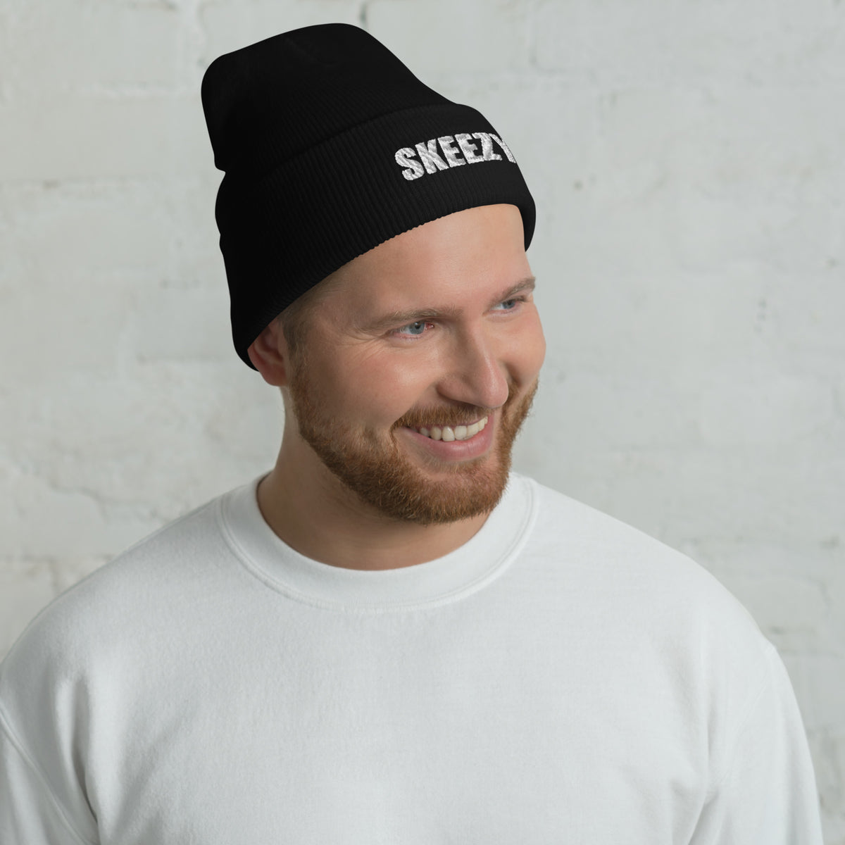 Man wearing the black Skeezy cuffed beanie with white SKEEZY embroidery