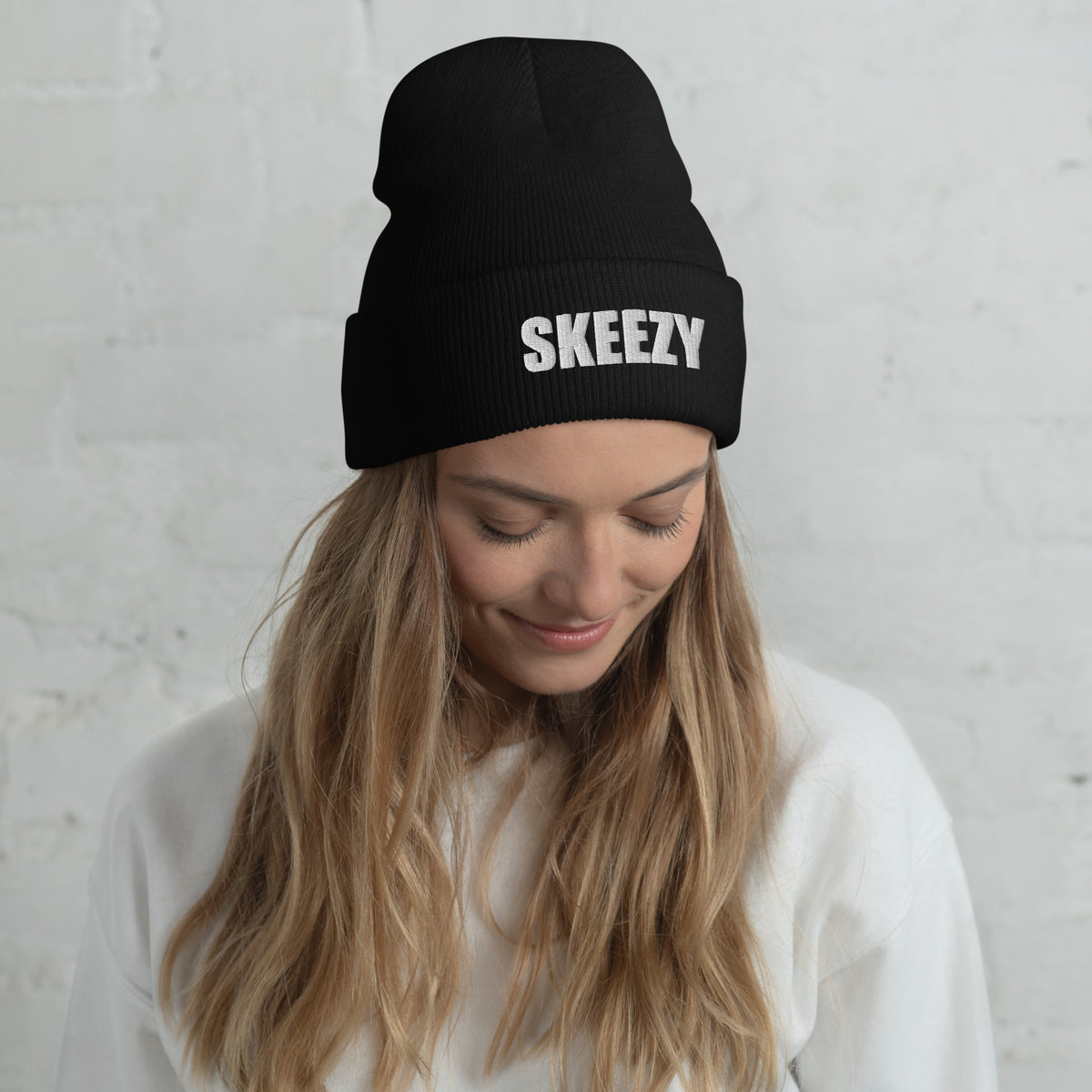 Woman wearing the black Skeezy cuffed beanie with white SKEEZY embroidery