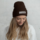 Woman wearing the brown Skeezy cuffed beanie with white SKEEZY embroidery
