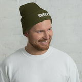 Man wearing the olive Skeezy cuffed beanie with white SKEEZY embroidery