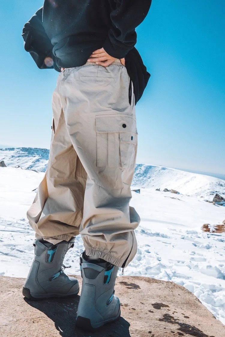 Sidehit Baggy Cargo Snow Pant in Khaki, back view showing the thigh cargo pocket and gathered cuffs