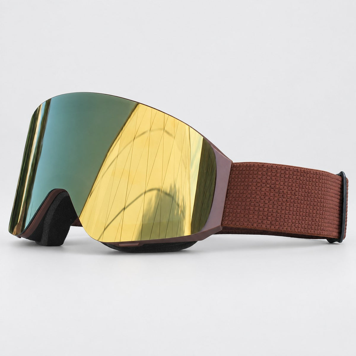 Snow goggle with a brown matte frame, gold mirror lens and brown textured strap, side view